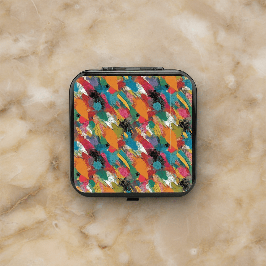 Black hardshell Nintendo Switch 24-slot game card case with colorful abstract brushstroke paint pattern in teal, orange, pink, black, and green