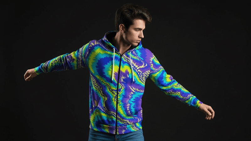 Model wearing Boundless Bleeds hoodie with vibrant paint-splatter tie-dye and acrylic pour-inspired design.