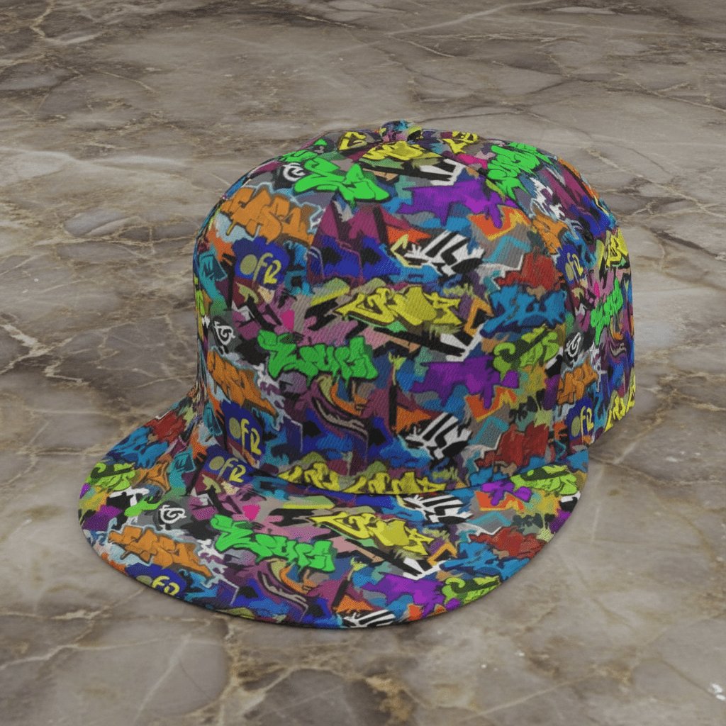 Graffiti Wildstyle snapback cap by Dyles Mavis — flat brim 6-panel cap with all-over print of neon green, purple and orange wildstyle graffiti tags, angled product shot on marble