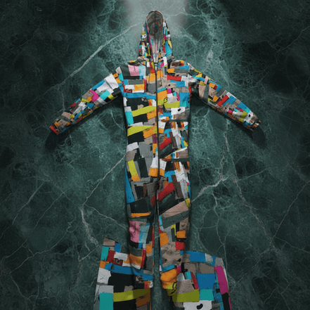 Scrap Quilt hazmat suit costume by Dyles Mavis — full-body hooded hazmat suit with all-over print of a colorful patchwork scrap-collage in orange, teal, pink, black and yellow, flat lay on dark marble