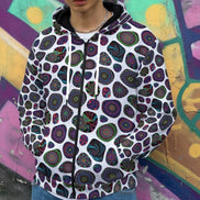 Biomorphic Mosaic Mark 11 zip-up hoodie by Dyles Mavis — heavy fleece hoodie with all-over print of intricate mandala medallions tessellated in an organic cell pattern on white, worn open over a white tee against a graffiti wall