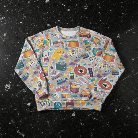 Toy Parade Hacci Knit Sweater drop-shoulder pullover in soft gray covered with playful toy stickers including drums, rubber ducks, stars, cassettes, and clocks in gold, teal, and coral