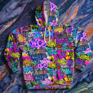 Chaos Wall Graffiti Hoodie pullover with dense neon graffiti pattern including CHAOS lettering, tags and throw-ups in purple, teal, pink, and yellow, white drawstrings, flat lay on marble
