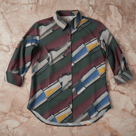 Jewel Stripe Blouse button-up with painterly diagonal stripe pattern in forest green, deep maroon, cream, cobalt blue, and gold, classic collar, flat lay on marble