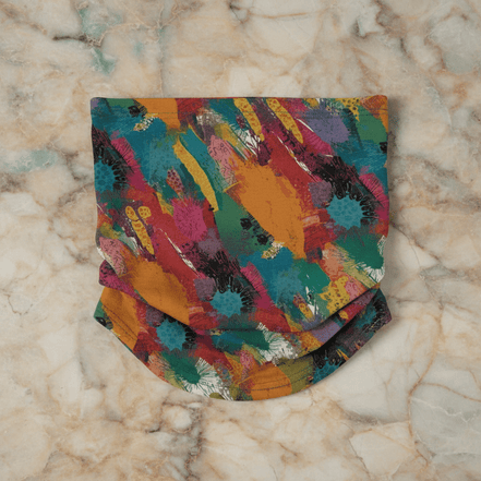 Painted Camo Neck Gaiter in quick-dry fabric with multicolor brush-dab pattern in orange, teal, crimson, magenta, and green, folded flat on marble