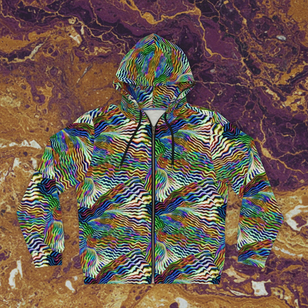 Zebra Swirl Zip Hoodie full-zip with hypnotic wavy micro-stripe pattern melting through green, blue, gold, red, and white swirls, flat lay on amber marble